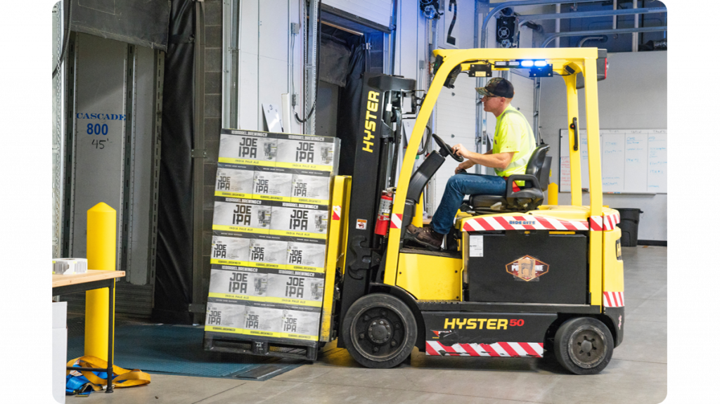man_driving_forklift_truck_in_a_warehouse
