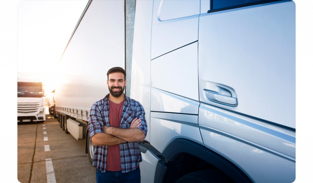 man_stood_next_to_silver_lorry_parked_up_in_a_bay